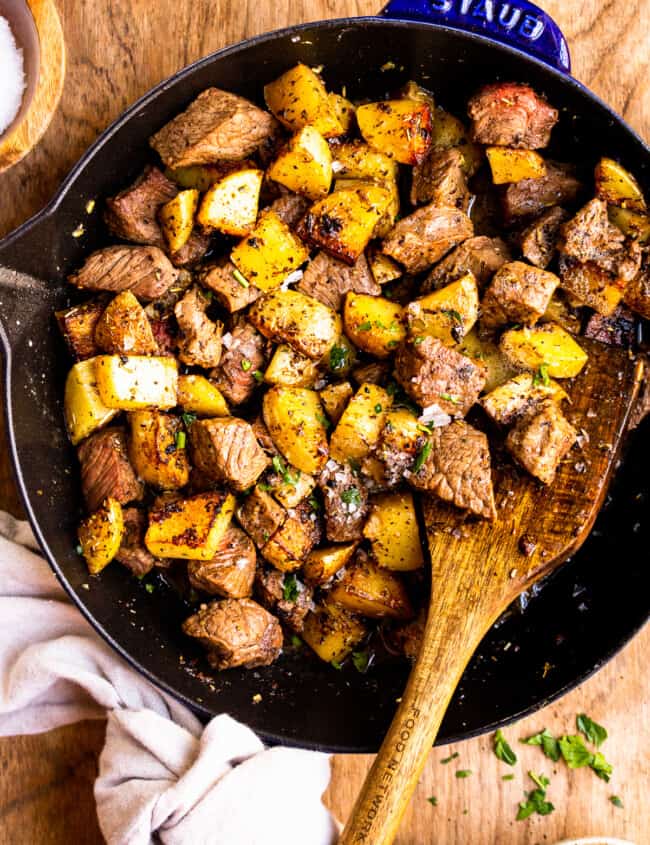 garlic butter steak bites with potatoes in skillet