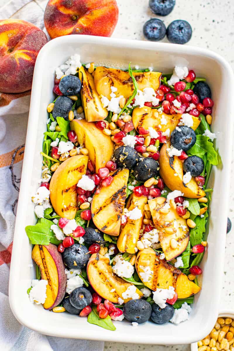 overhead grilled peach salad in white serving dish