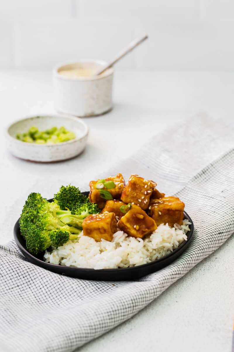 air fryer teriyaki tofu on a black plate.