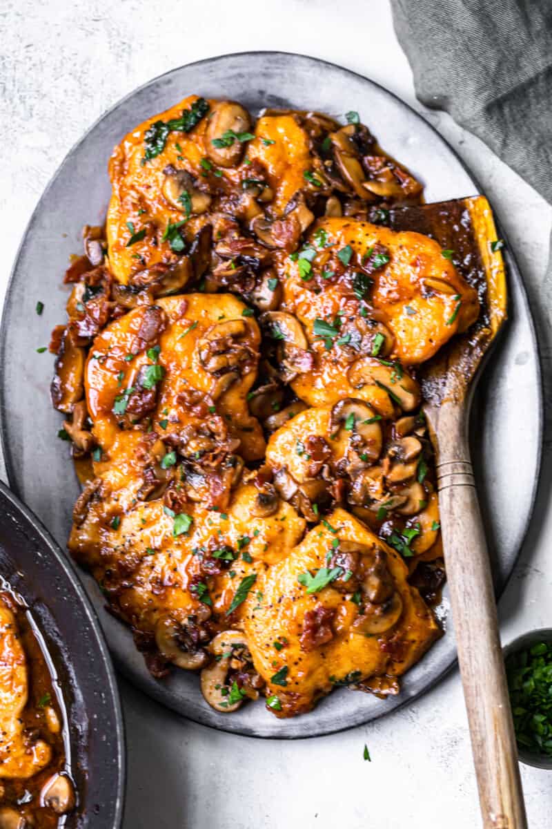 chicken marsala on platter with wooden spoon