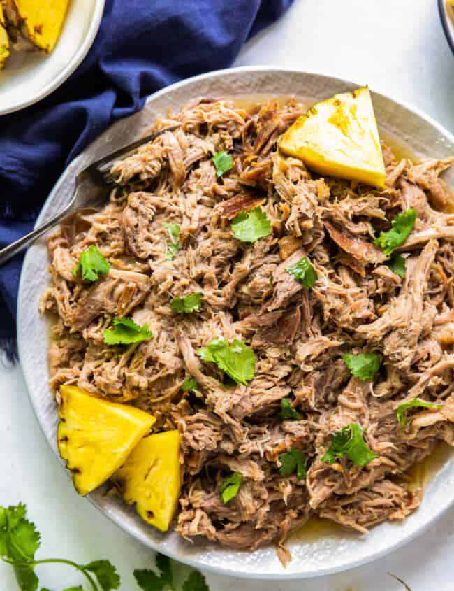 overhead plate of kalua pork on plate with pineapple slices