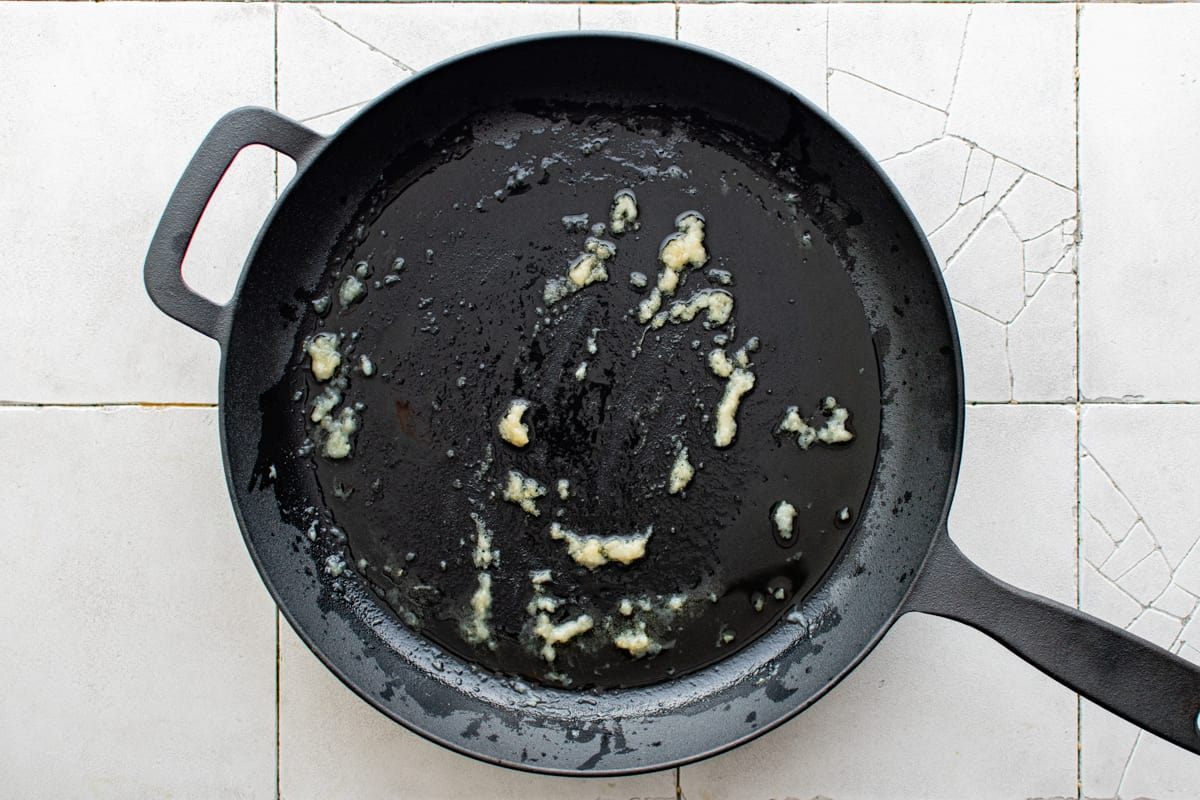 garlic and ginger past sizzling in a cast iron skillet.