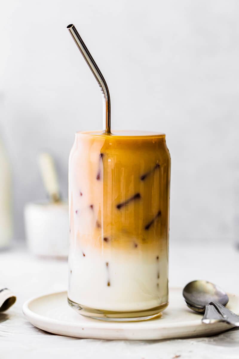 iced chai tea latte in glass cup with metal straw