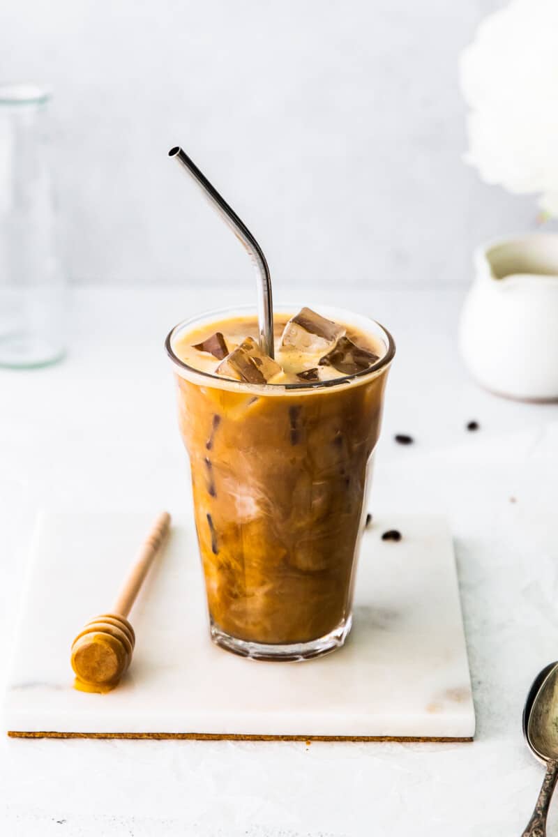 honey almondmilk flat white in clear glass with straw