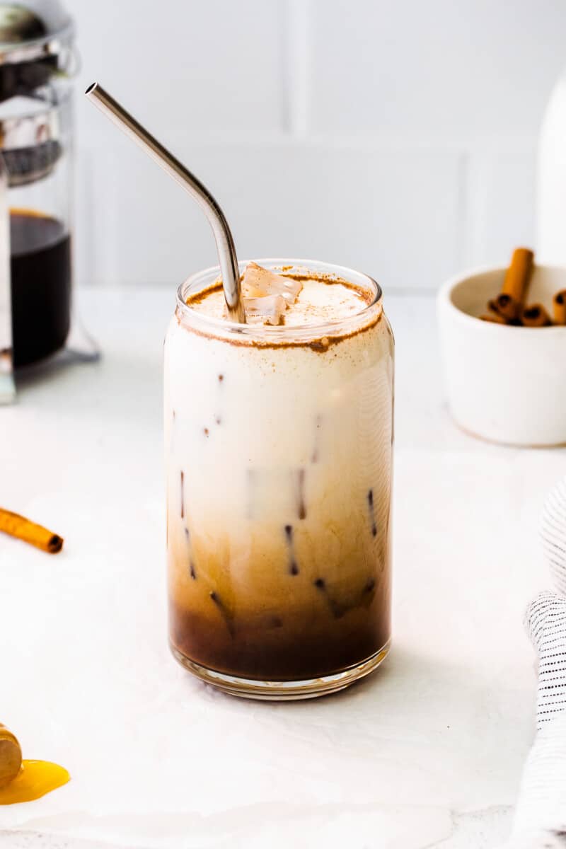 glass of iced honey cinnamon latte with metal straw