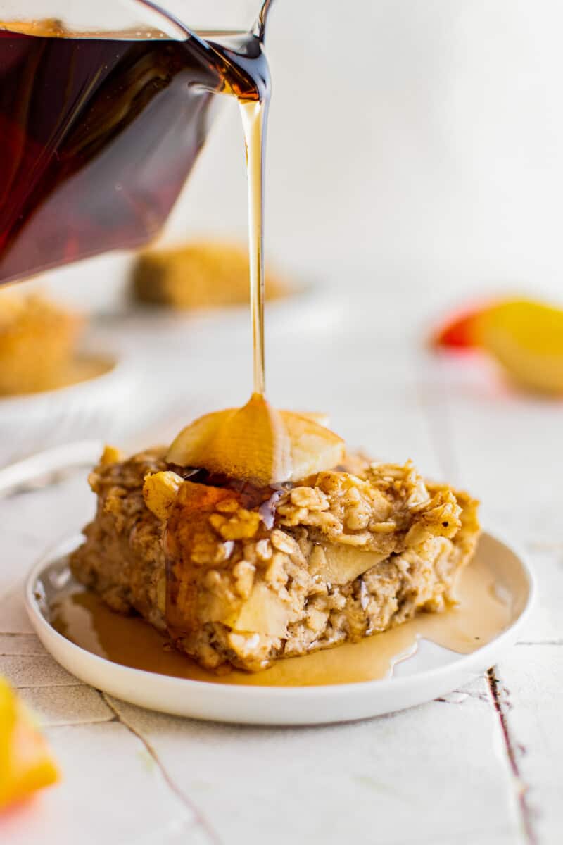 drizzling maple syrup on baked apple oatmeal