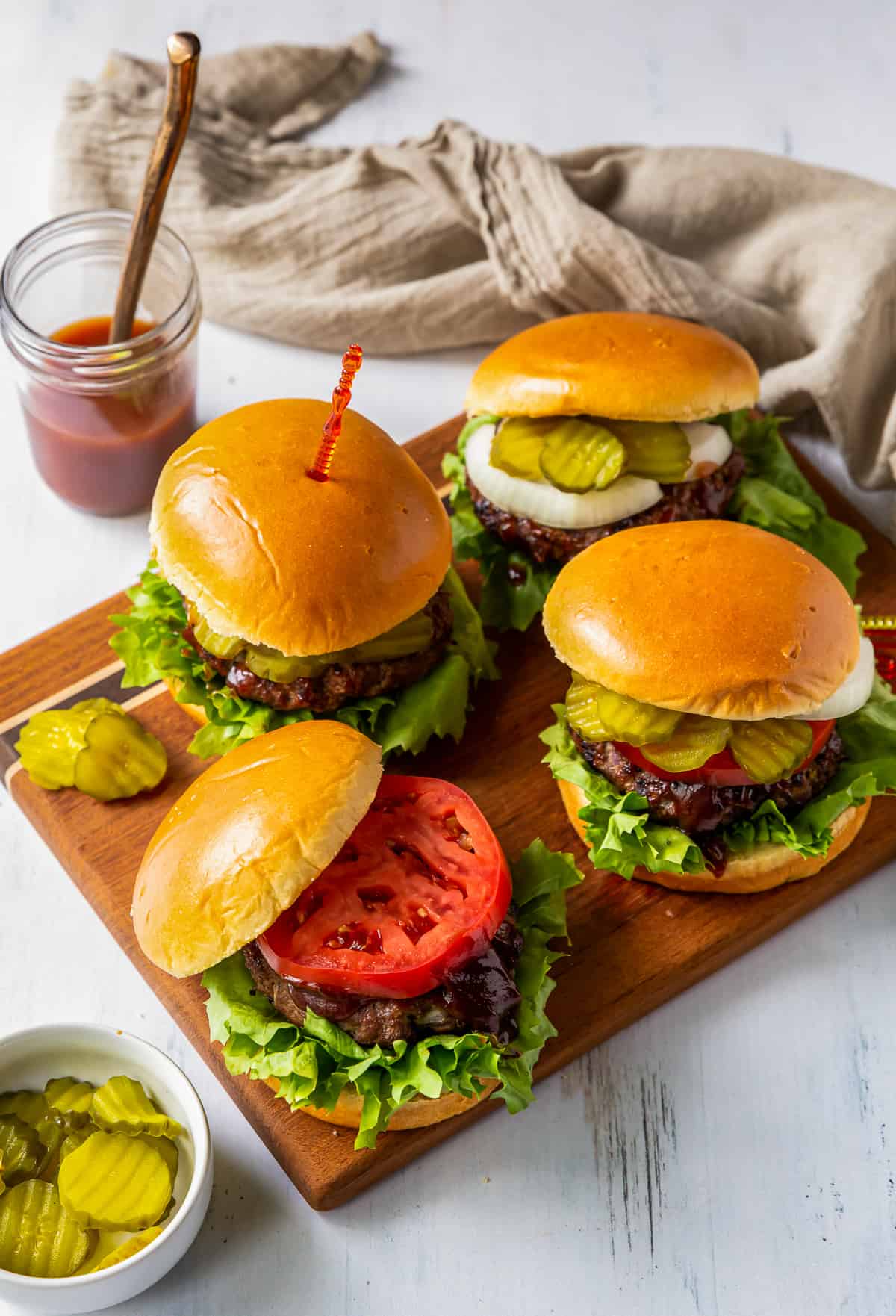 burgers on a wooden cutting board.