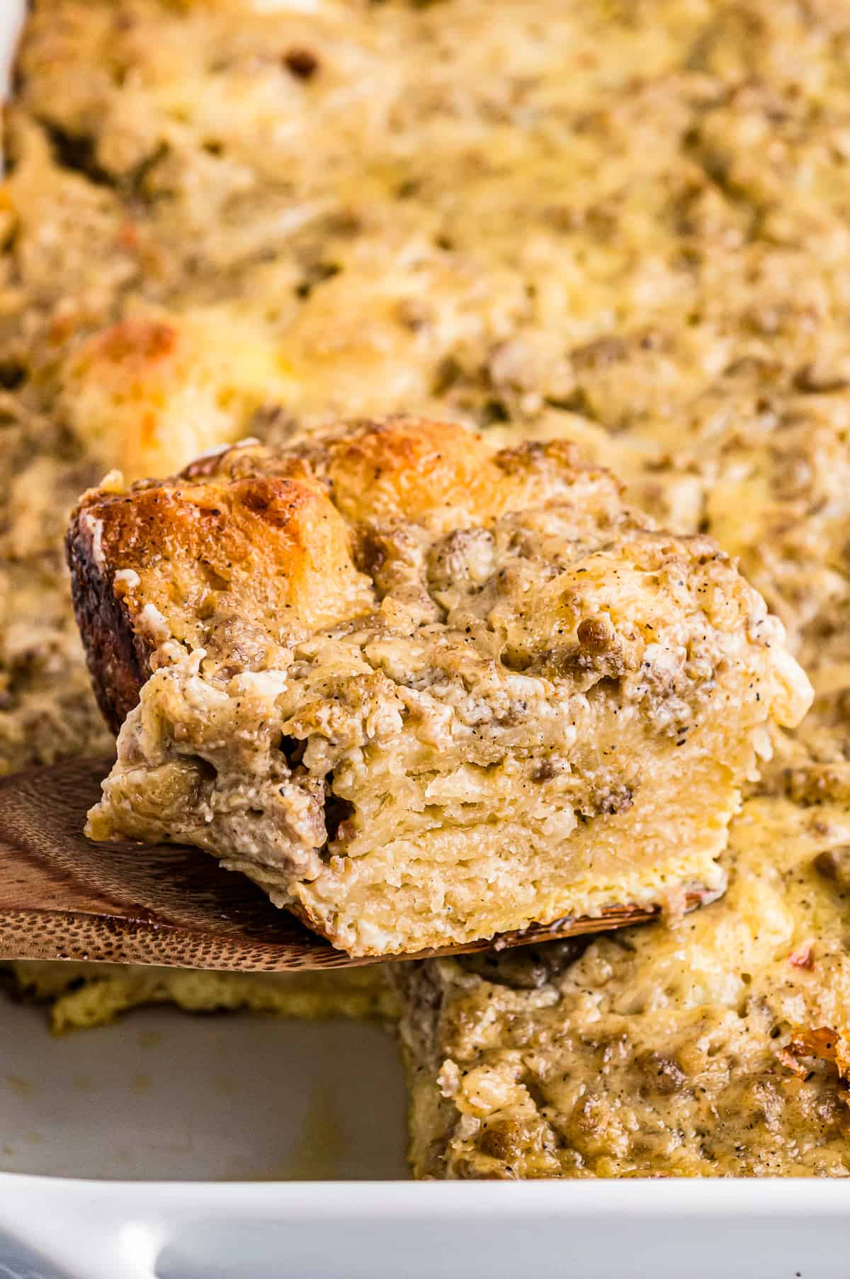 piece of biscuits and gravy casserole on a wood spatula