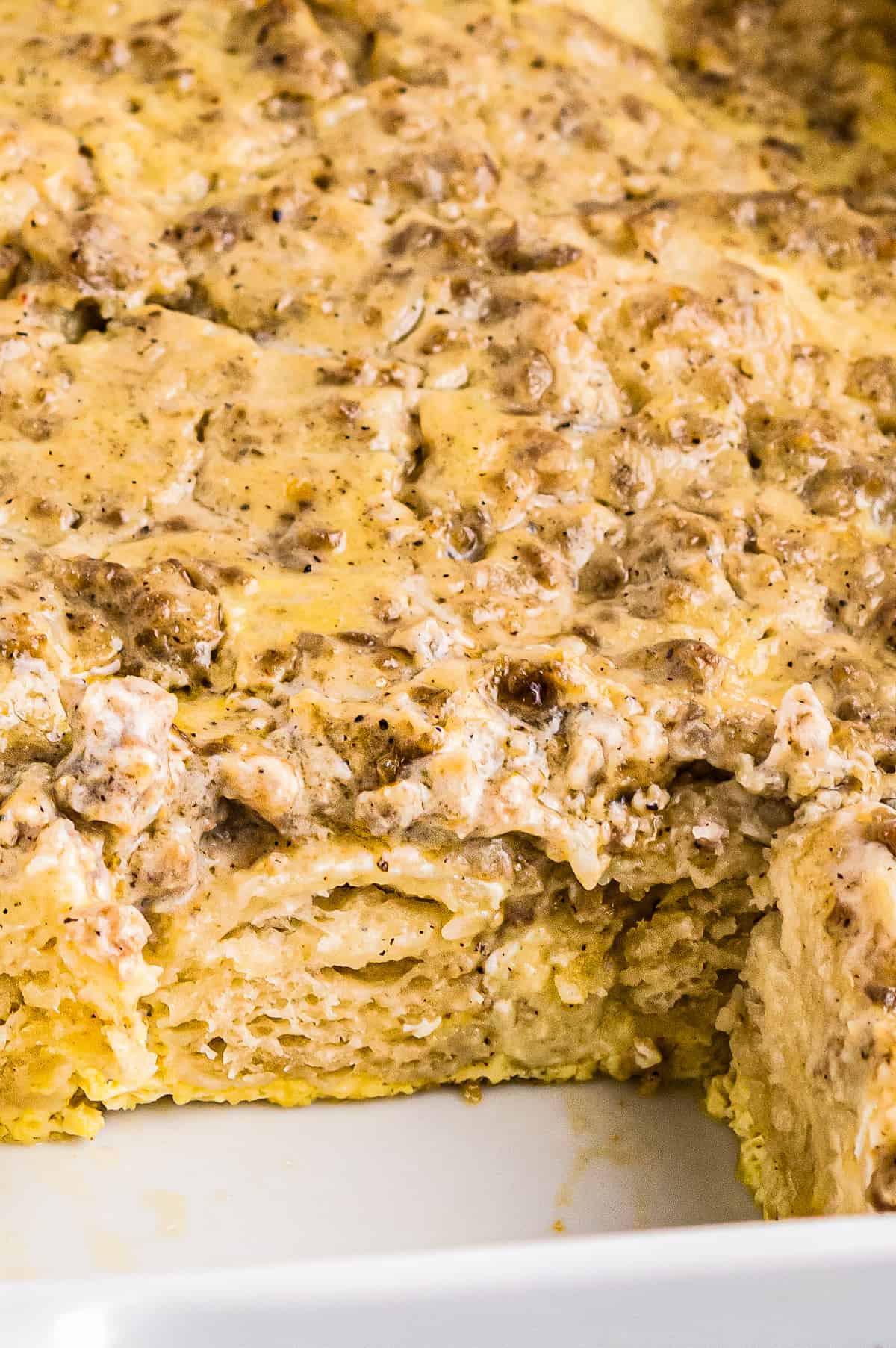 close up image of biscuits and gravy casserole in a white baking pan showing the texture