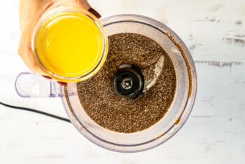 adding melted butter to graham cracker crumbs in food processor