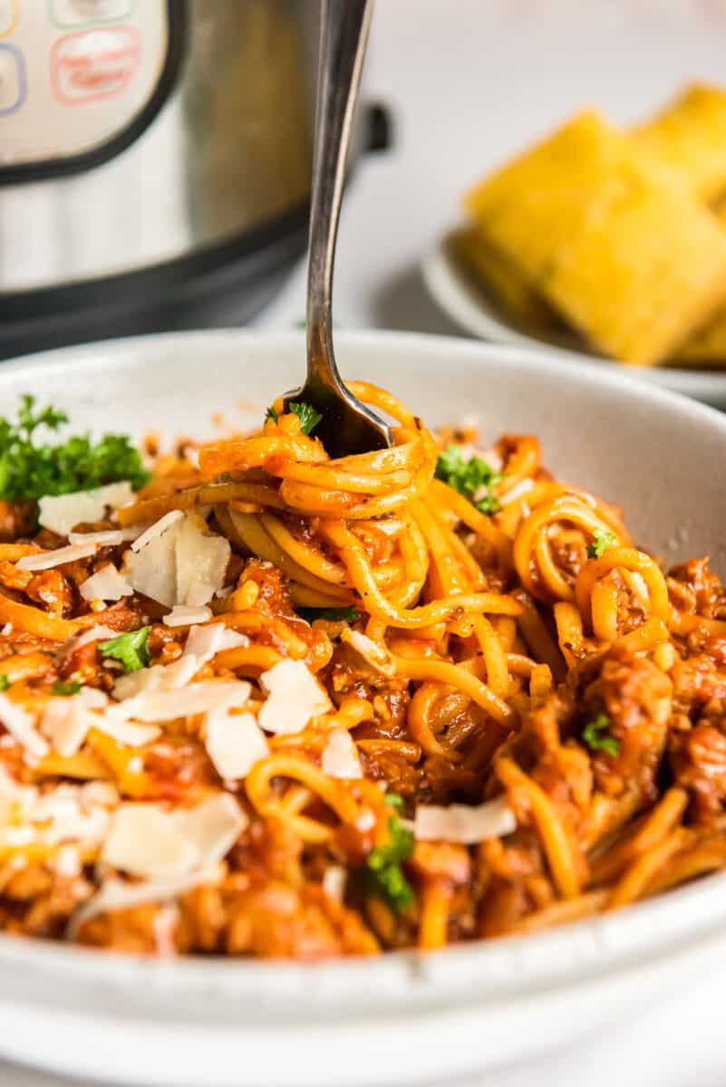 fork twirling spaghetti in a white bowl