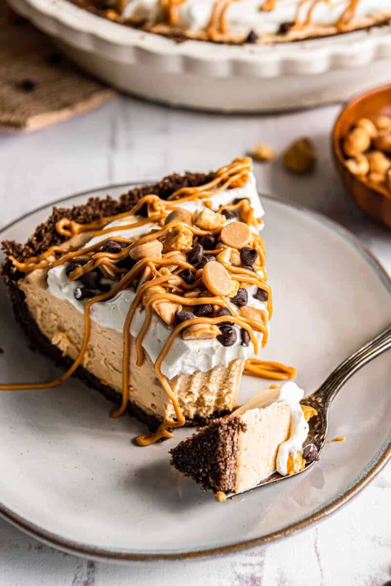 slice of peanut butter pie with a fork on a white plate