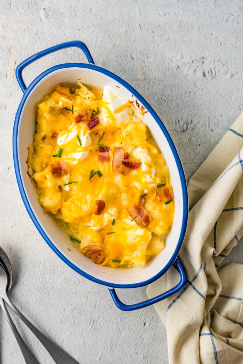 overhead view of loaded cauliflower bake in a blue and white casserole dish.