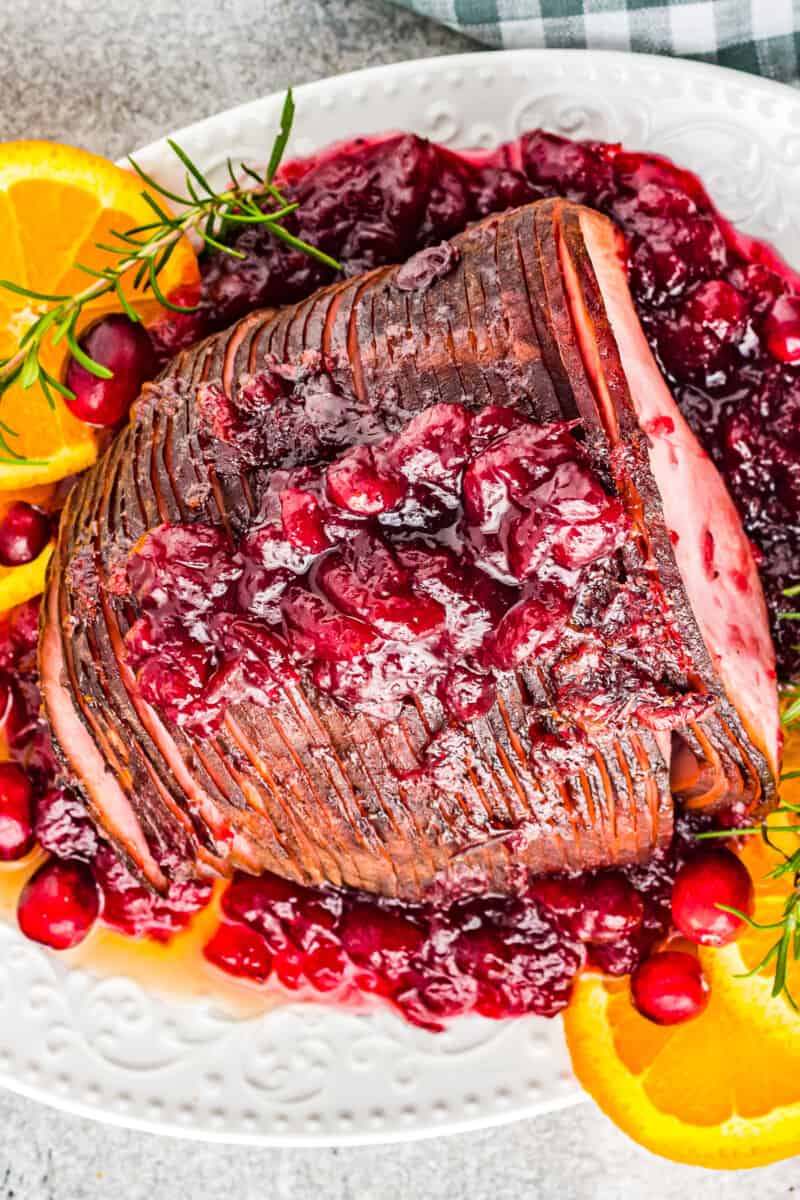 overhead image of cranberry glazed ham on a white serving platter