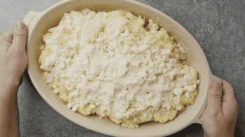 cheese topped mashed potatoes in a baking dish.