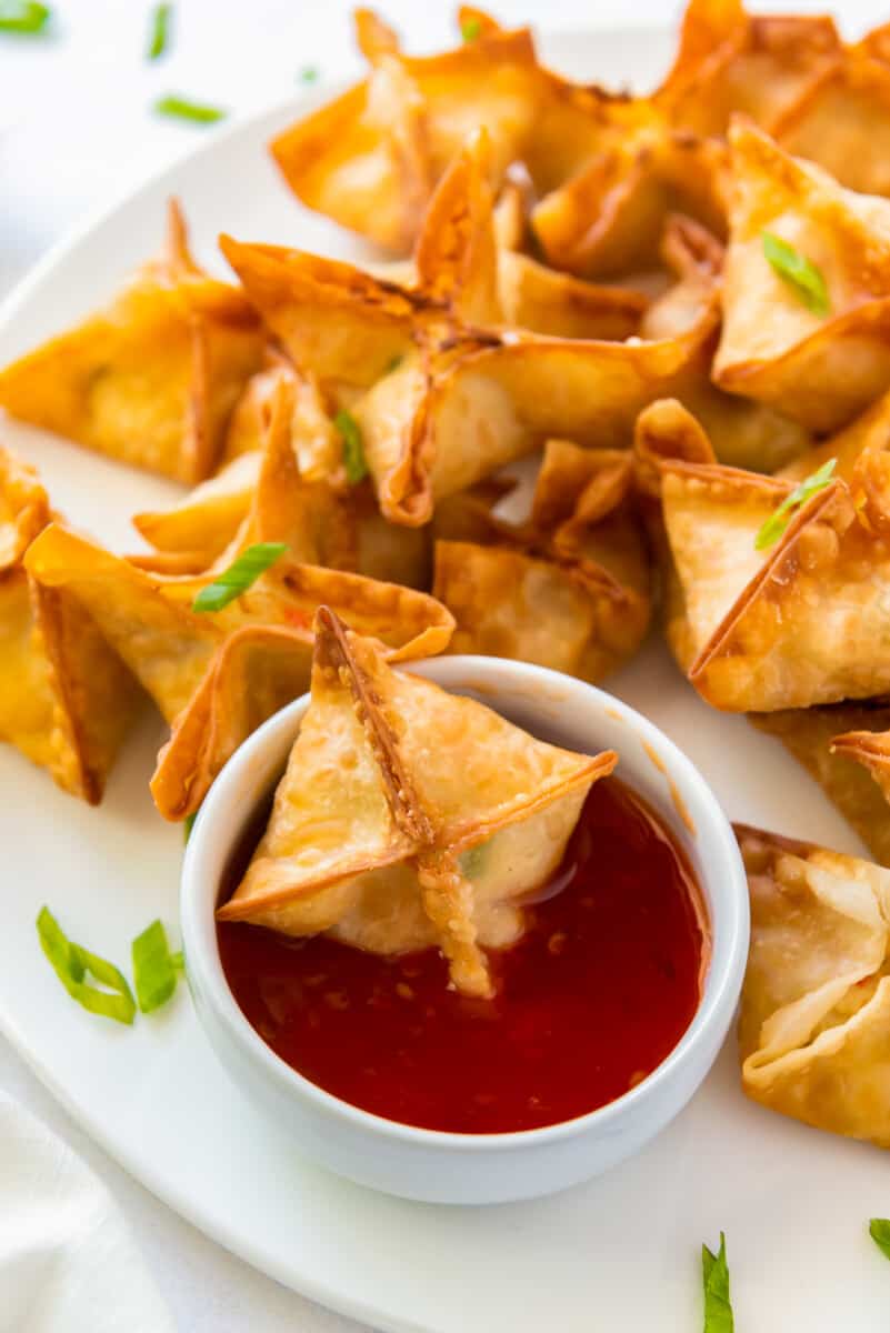 crab rangoon with one dipped in sweet and sour sauce