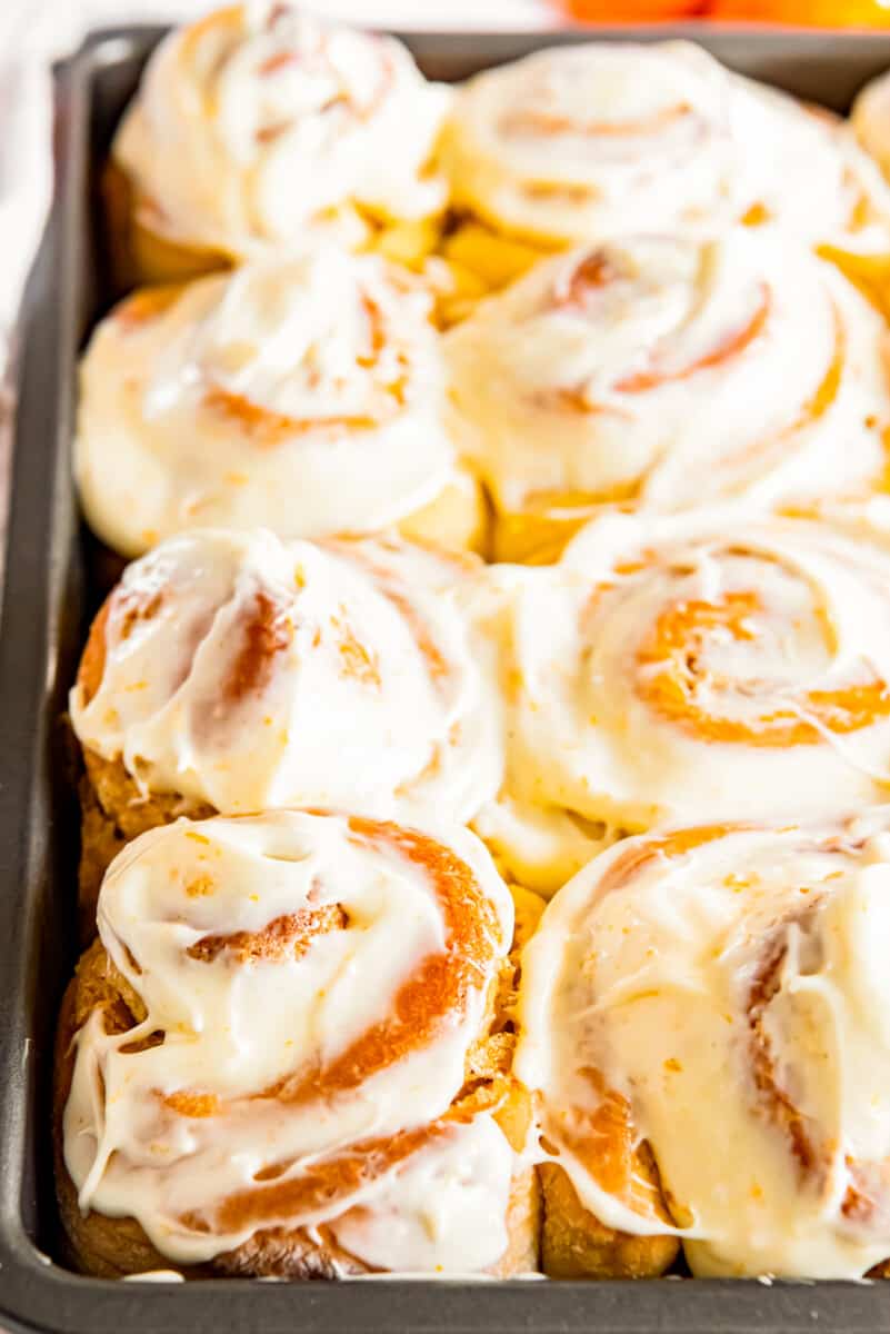 frosted orange rolls in baking dish