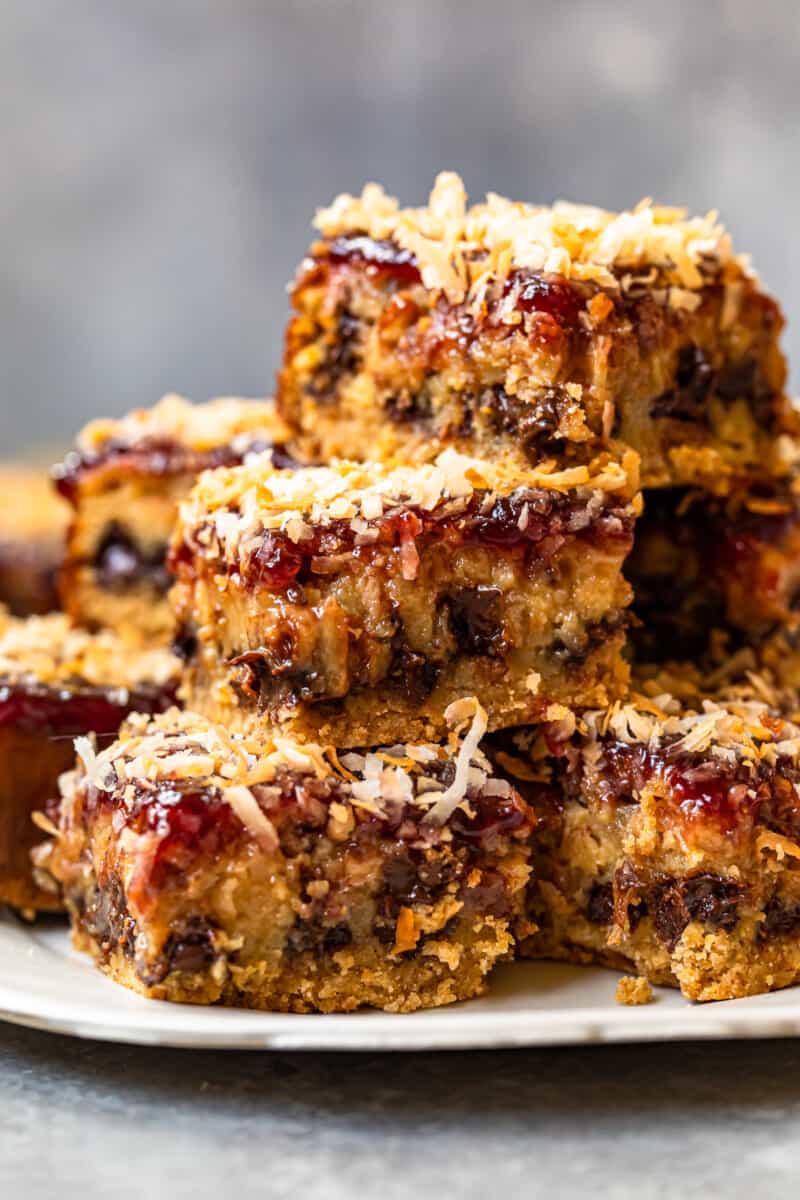 stack of raspberry chocolate coconut bars on a white serving plate