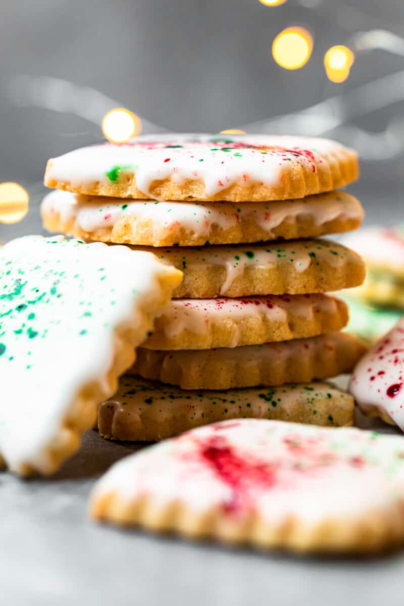 stack of square sugar cookies topped with white icing and green and red splatter decoration