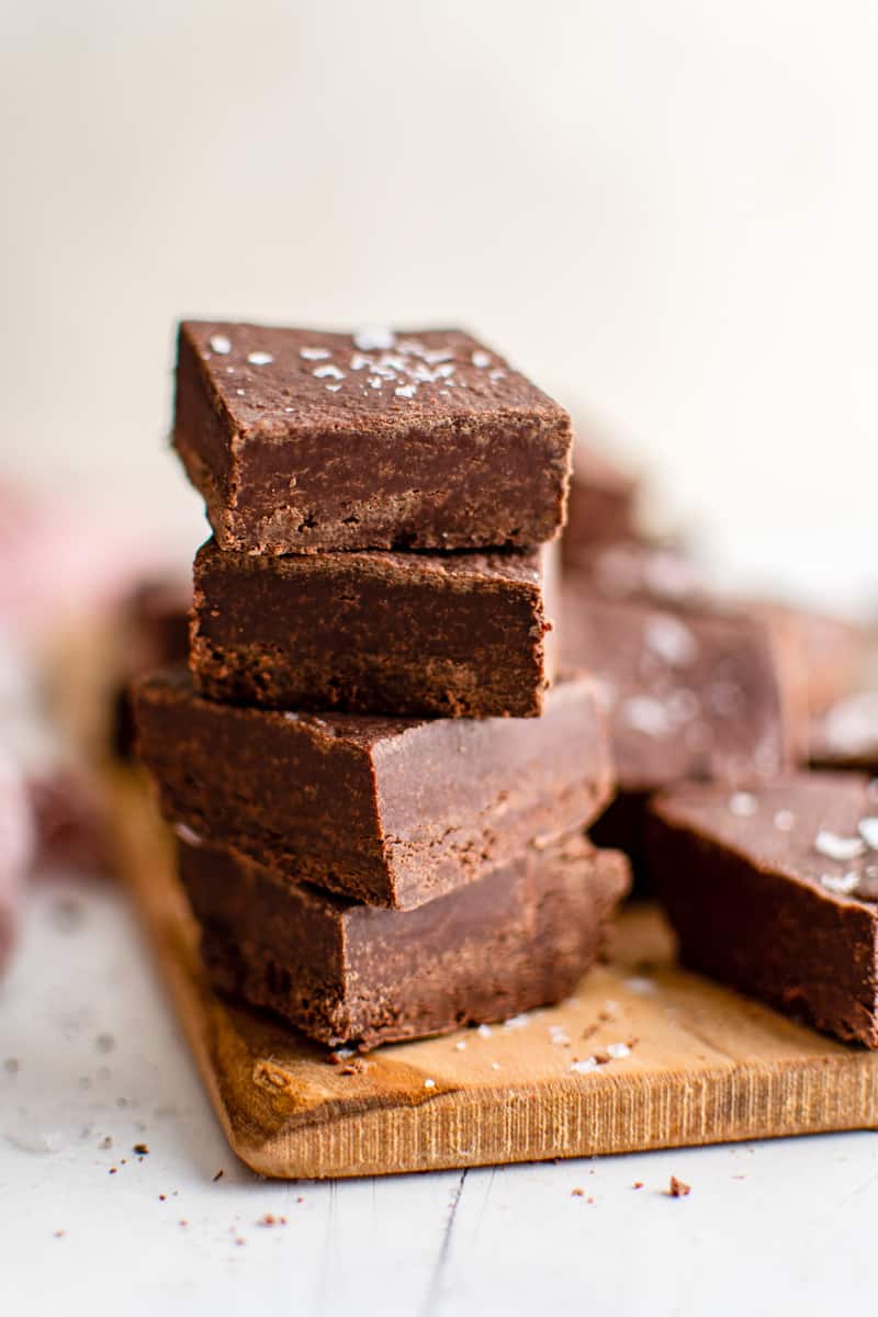 stack of 4 squares of chocolate fudge on a wood board