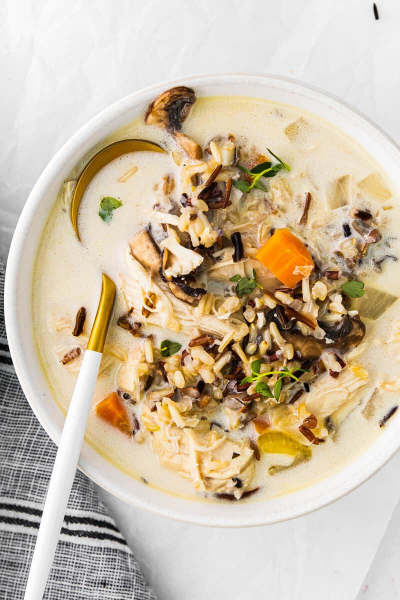 crockpot chicken wild rice soup in a white bowl with a spoon