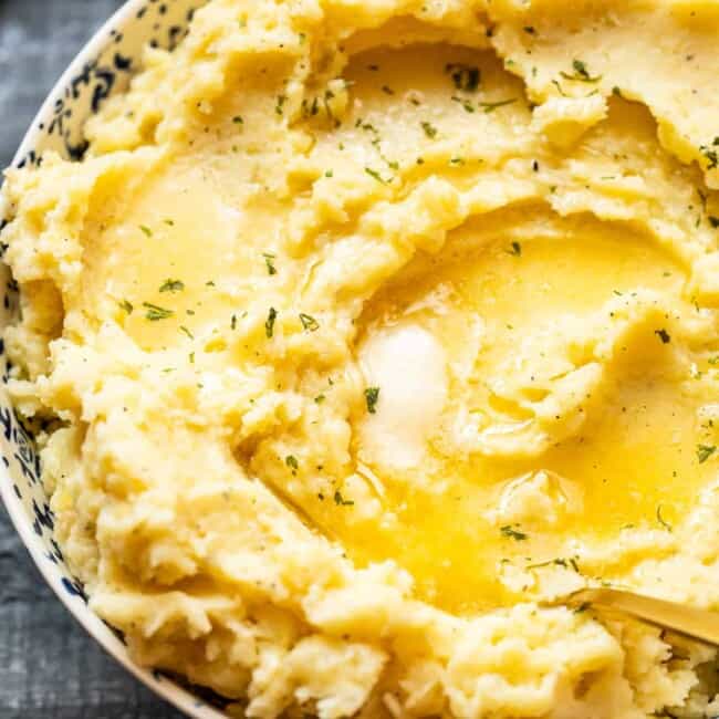 mashed potatoes in a bowl with butter on top with a spoon