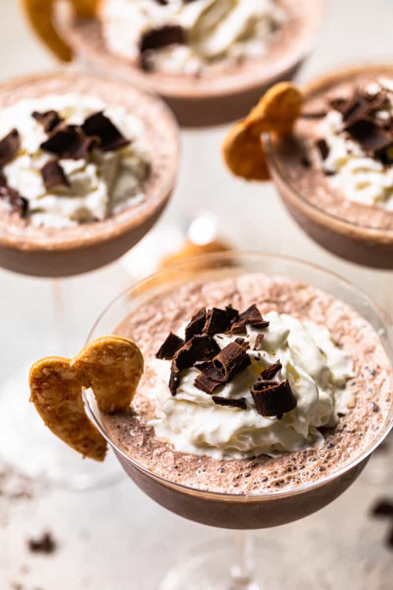 frozen french silk pie cocktails in glasses topped with whipped cream and chocolate shavings and garnished with baked pie crust cookies