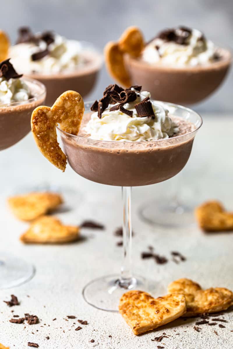 frozen french silk pie cocktails in glasses topped with whipped cream and chocolate shavings and garnished with baked pie crust cookies