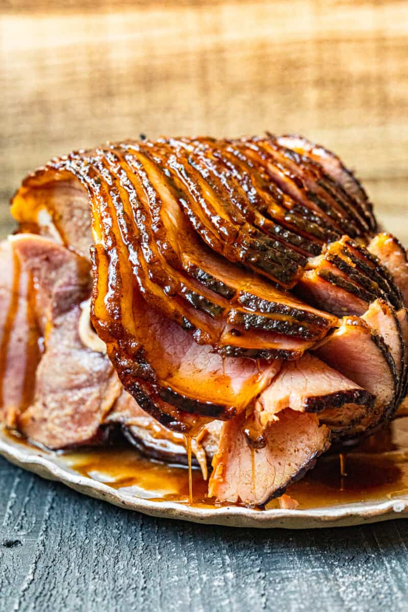 sliced honey baked ham on a white serving platter