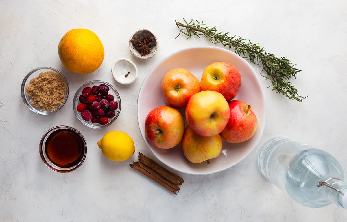 Ingredients for Instant Pot apple cider arranged in dishes.