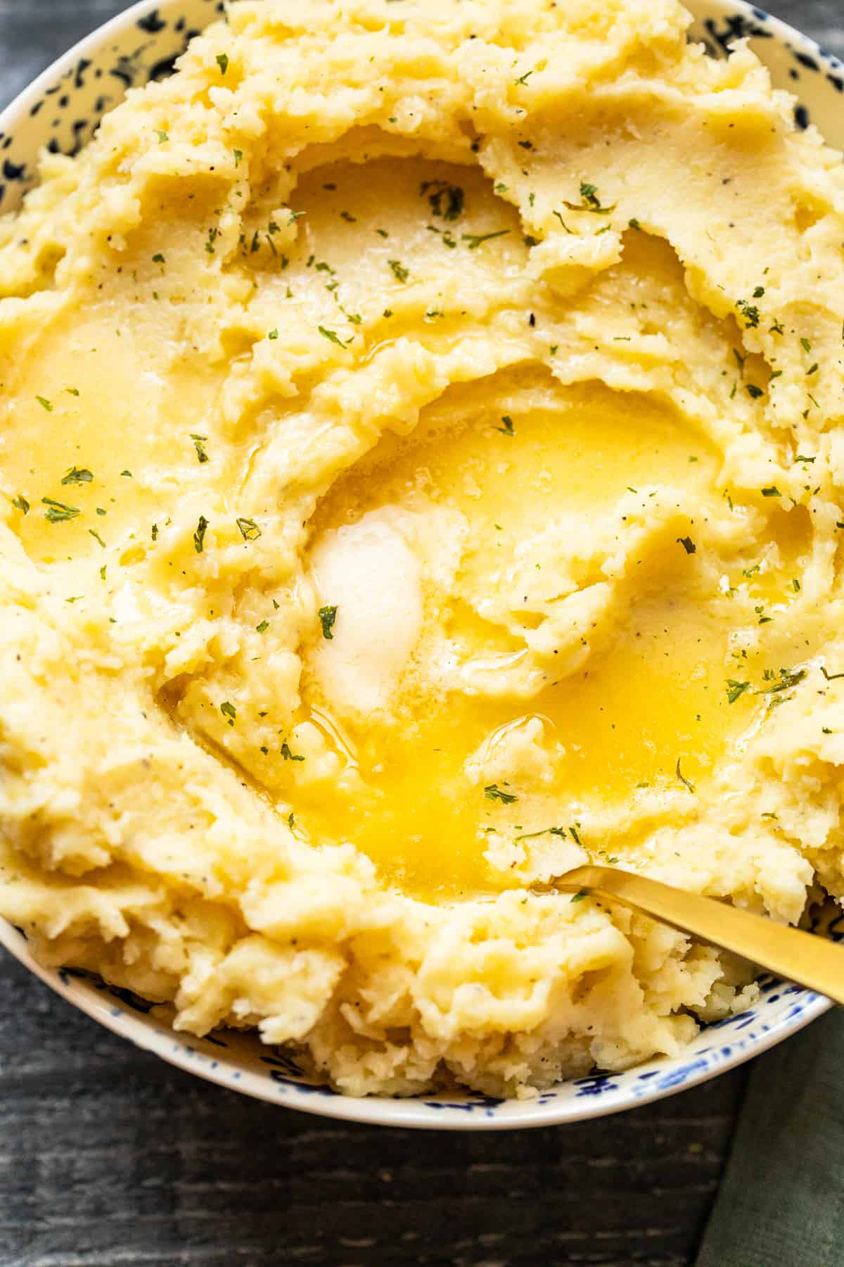 mashed potatoes in a bowl with butter on top with a spoon