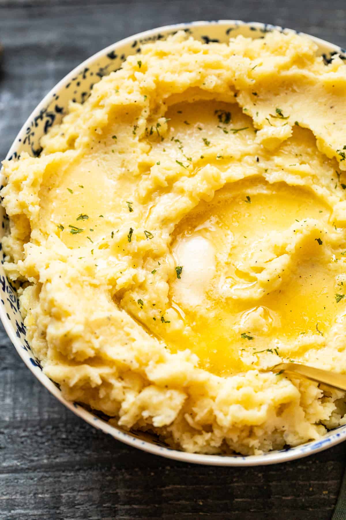 mashed potatoes in a bowl with butter on top with a spoon