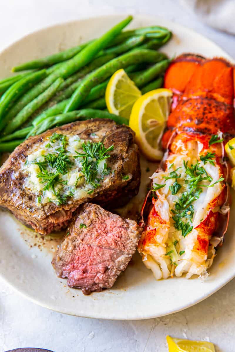 lobster tail and filet mignon with green beans on a plate