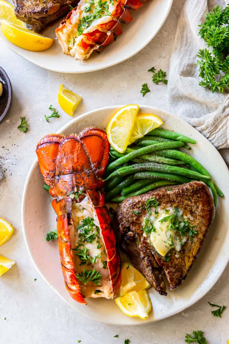 lobster tail and filet mignon with green beans on a plate