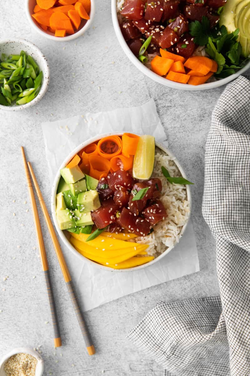 tuna poke bowl in a white bowl with chopsticks.