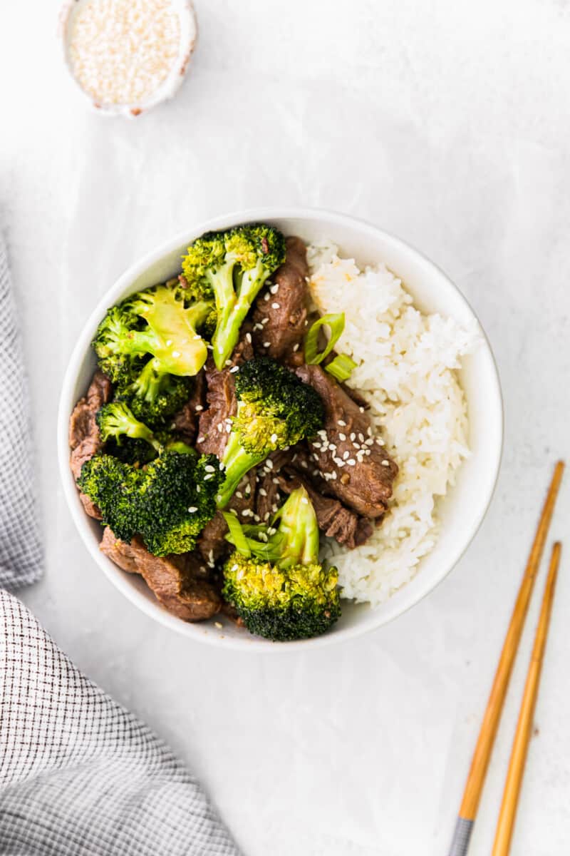 overhead image of beef and broccoli with rice in a white bowl