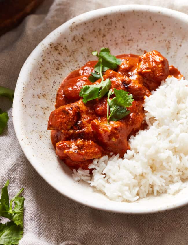 white bowl with chicken tikka masala and rice