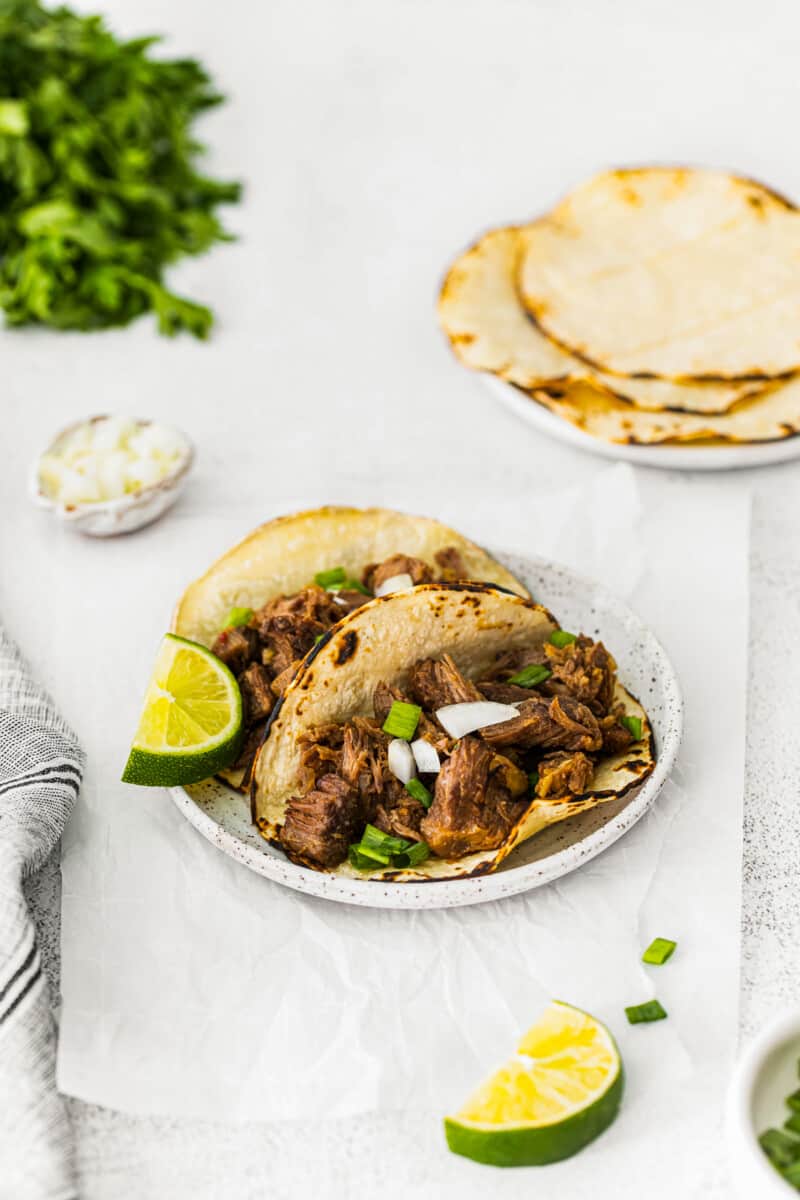 2 beef carnitas tacos on a white plate