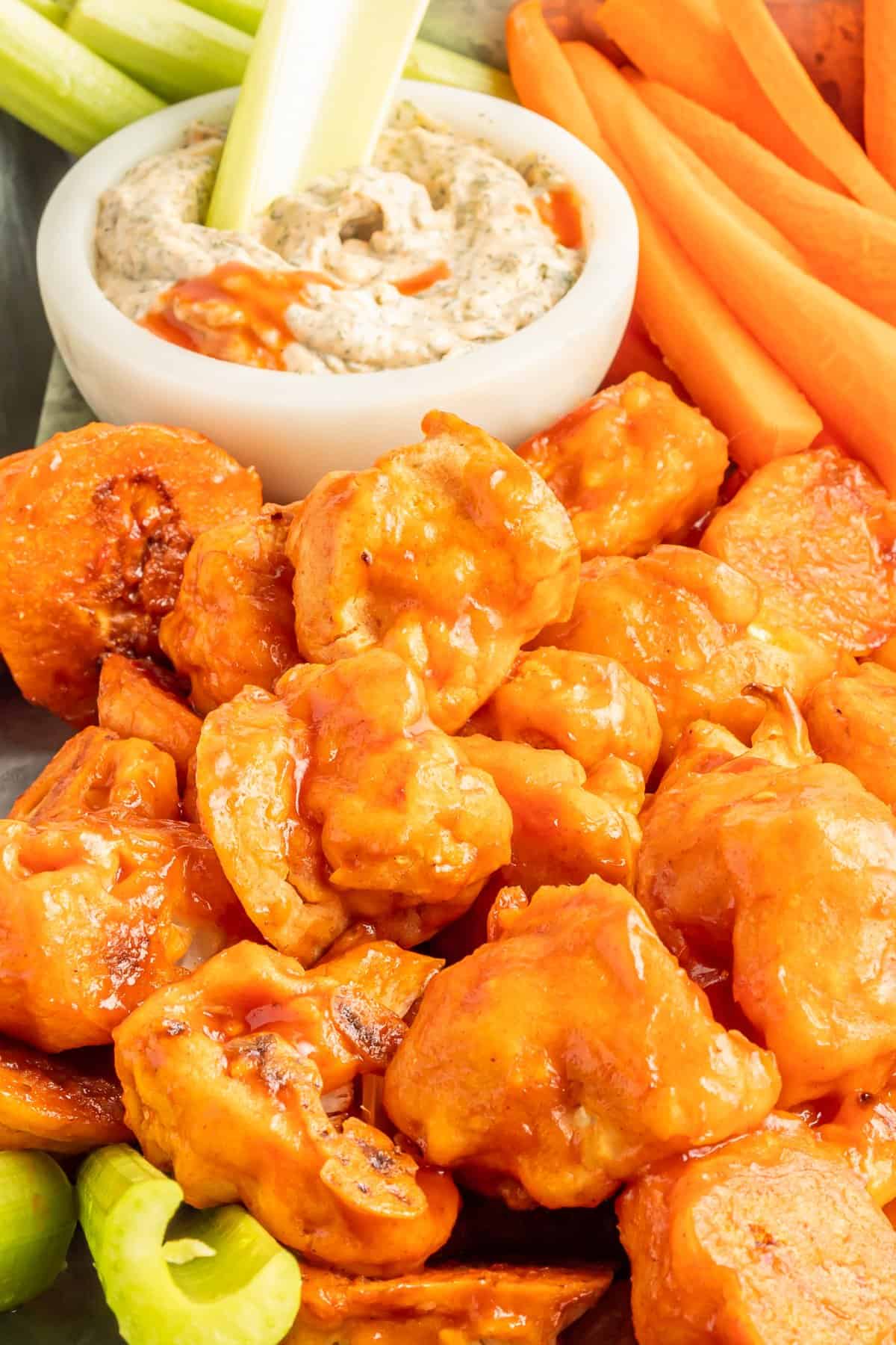 buffalo cauliflower wings on a serving tray with buffalo ranch dressing in a white bowl