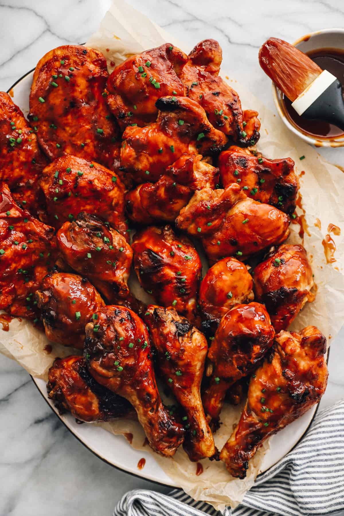 baked bbq chicken breasts, thighs, and drumsticks on a serving platter