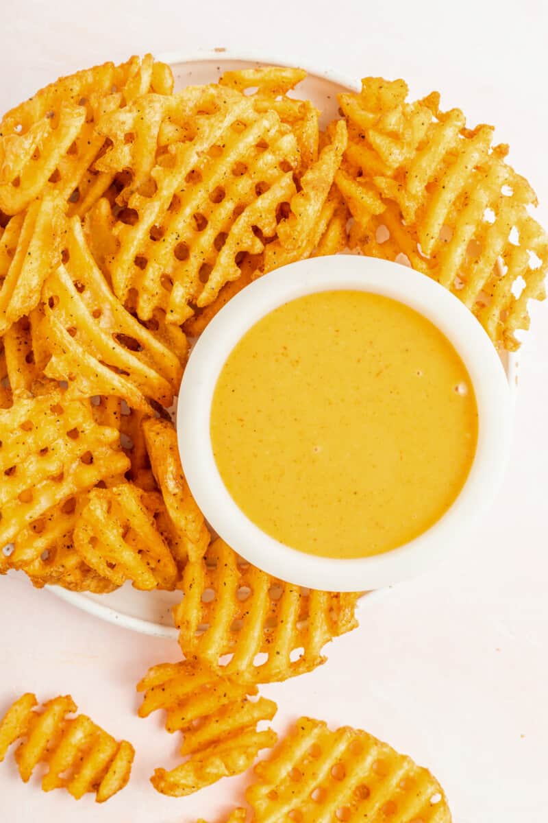 chick-fil-a sauce in a white bowl on a serving platter with waffle fries