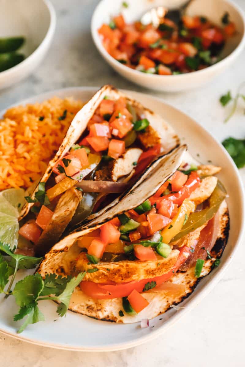 chicken fajitas on a white plate with rice