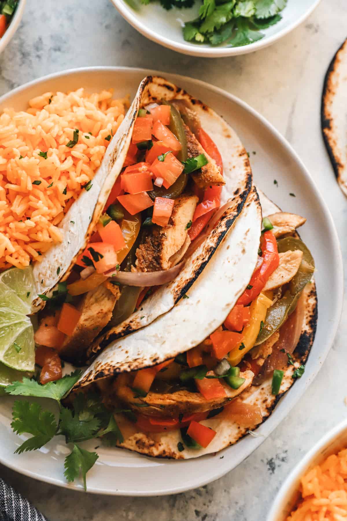 chicken fajitas on a white plate with rice