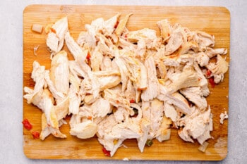 shredded chicken on a wood cutting board