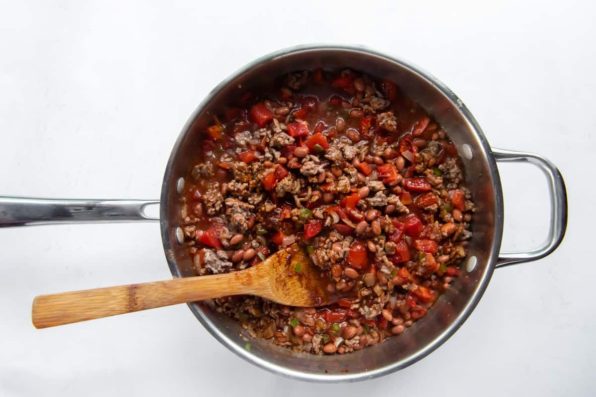 chili in a pot with a wood spoon