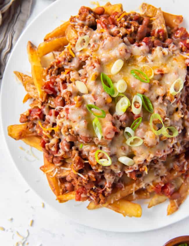 overhead image of chili cheese fries on a white plate