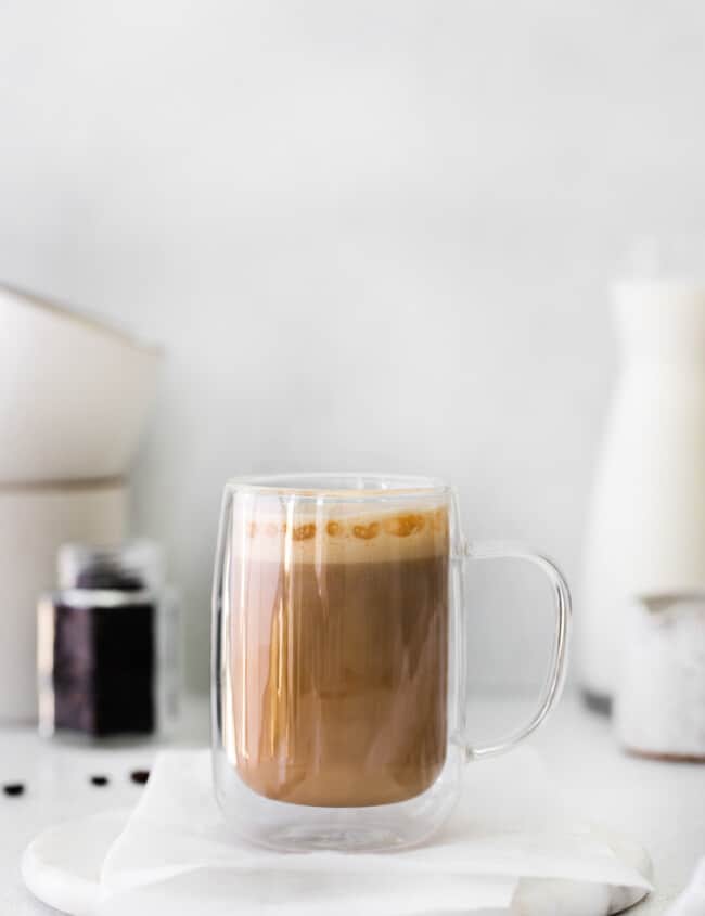 flat white drink in a glass mug