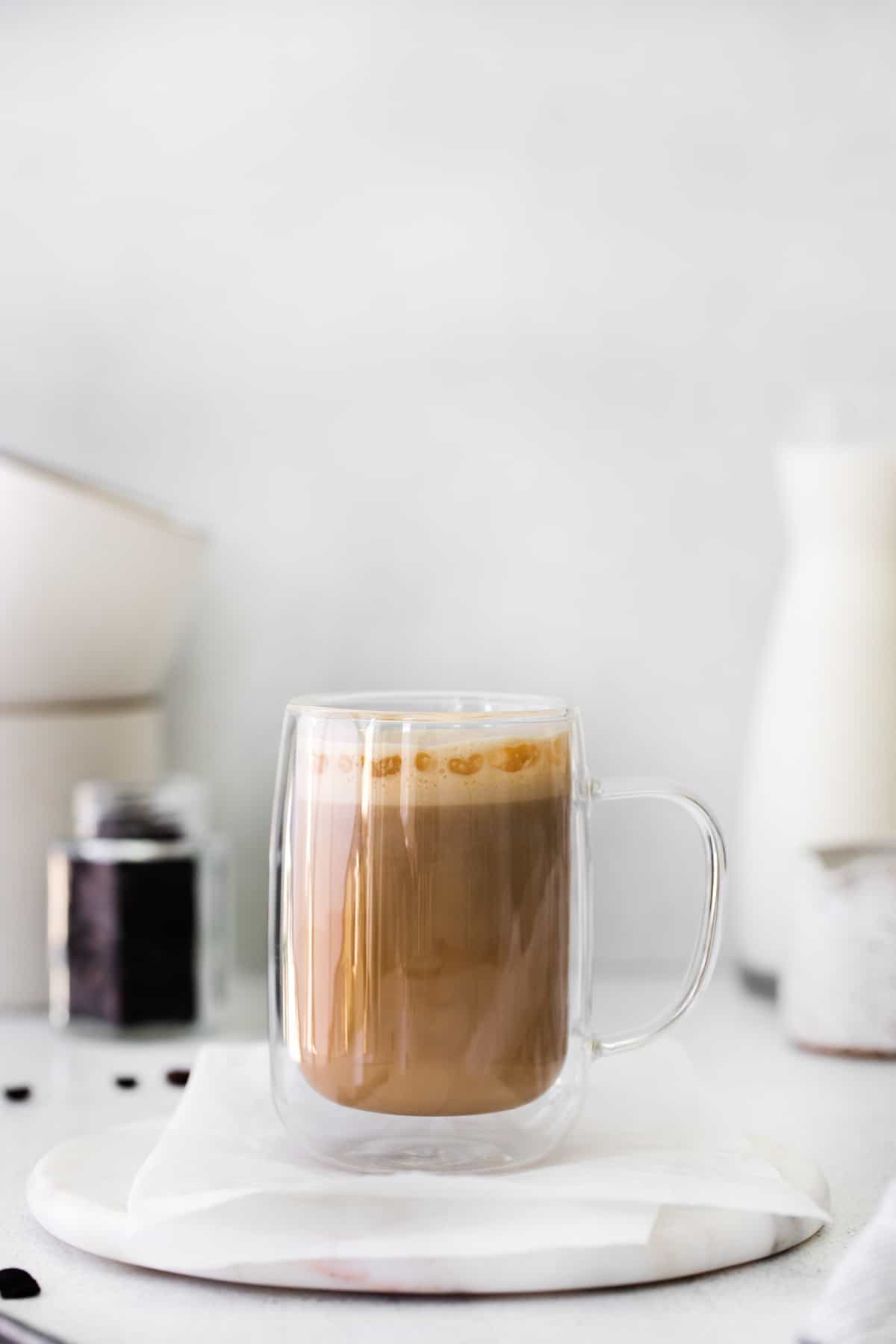 flat white drink in a glass mug