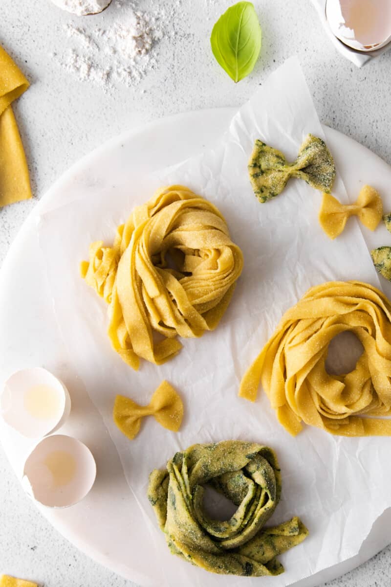 overhead view of 3 nests of homemade pasta on a round marble server.