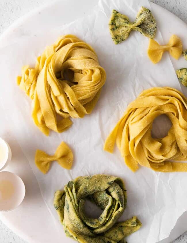 overhead view of 3 nests of homemade pasta on a round marble server.